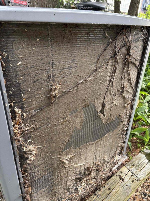 Completed annual cooling maintenance on 16-year-old Allied air conditioning system. Upon arrival, found outdoor condenser unit heavily soiled with significant accumulation of dirt, dust, and dried plant debris including vines draped across coil surfaces. Cleared all organic matter and debris from condenser coil and surrounding unit. Performed thorough coil cleaning to restore proper airflow and heat transfer efficiency. Inspected unit components, verified system operation, and confirmed equipment functioning properly following maintenance procedures.