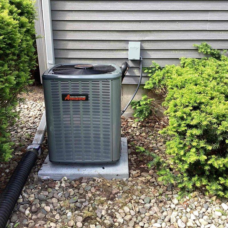 Completed full air conditioning system replacement including outdoor condensing unit and indoor air handler. New outdoor unit installed on existing concrete pad with proper refrigerant line connections, electrical hookup, and condensate drainage. Indoor equipment installed in basement utility area with all ductwork connections, PVC condensate lines, and electrical wiring completed per manufacturer specifications. System tested and verified operational with proper airflow and cooling performance.