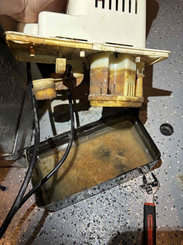 Completed annual cooling tune-up on 11-year-old EnergiAir system with 2020 condenser model. Upon inspection, discovered significant corrosion and rust on burner assembly and housing components, with standing water and sediment accumulation in collection pan indicating potential drainage issues. Disassembled unit to assess extent of corrosion damage, documented conditions with photos, and provided recommendations for component replacement due to advanced deterioration that could affect system reliability and efficiency.
