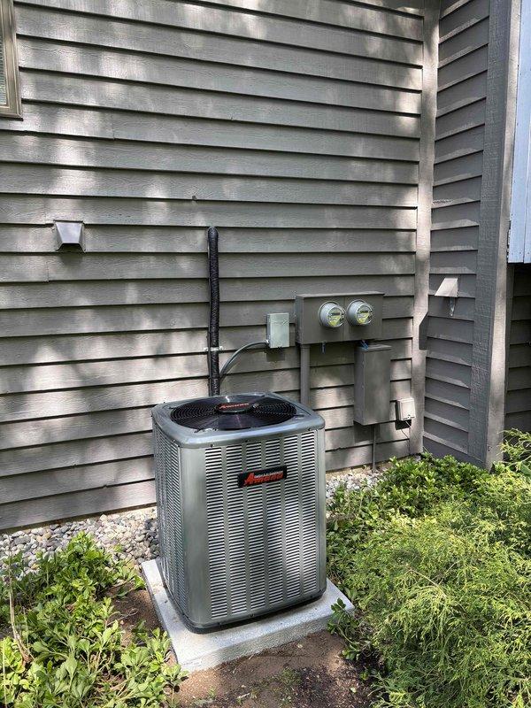 Completed full air conditioning system replacement at residential property. Removed existing AC unit and installed new gray condenser unit on prepared concrete pad with proper gravel drainage base. Ran new refrigerant lines from condenser to house exterior, securing lines along wall with appropriate fasteners. Installed electrical disconnect box and conduit on exterior siding per code requirements. Connected unit to existing electrical service at meter location. Performed system startup, verified proper refrigerant charge levels, tested electrical connections, and confirmed optimal airflow and cooling performance. System operating within manufacturer specifications upon completion.