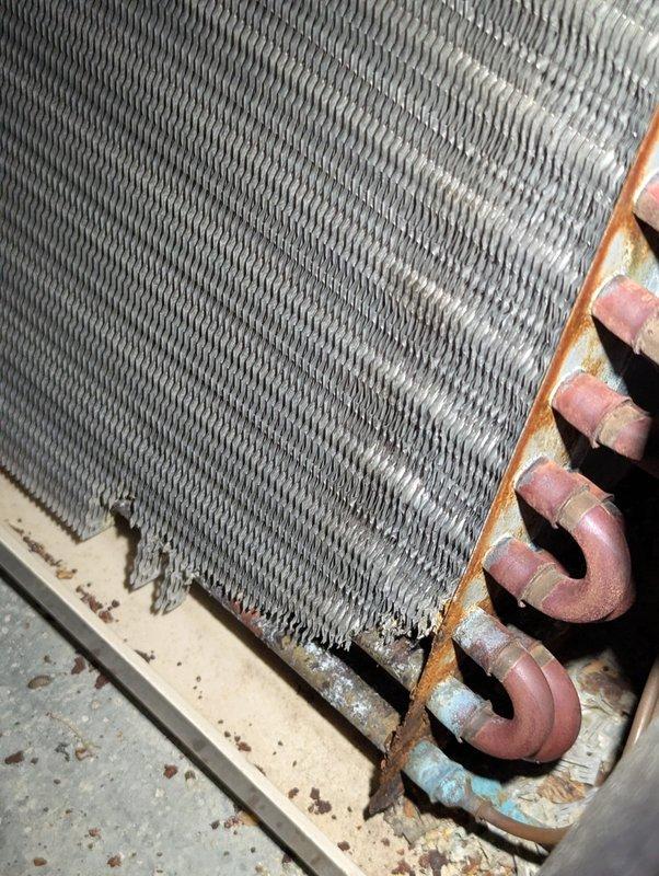 Completed annual cooling maintenance on 24-year-old Amana system. Inspected evaporator coil assembly showing normal dust accumulation on fins with copper refrigerant lines displaying age-appropriate patina. Verified condensate pump operation and drainage system functionality with proper PVC piping configuration in mechanical space.