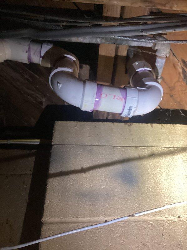 Completed rebuild of bathroom group drain line in crawl space. Removed deteriorated piping and installed new white PVC drain configuration with proper P-trap assembly, secured all connections with metal clamps per code requirements. All work performed in confined space with proper vapor barrier protection maintained throughout installation.