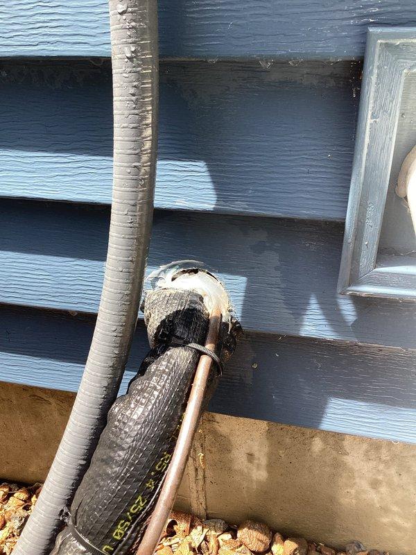 Completed annual AC tune-up on system less than 10 years old. Discovered damaged insulation on exterior refrigerant line with exposed copper and significant frost/ice buildup at wall penetration point, indicating possible refrigerant leak or restriction. Documented conditions with photos for customer review and recommended repair of damaged line insulation and further diagnostic testing to determine cause of abnormal frost formation.