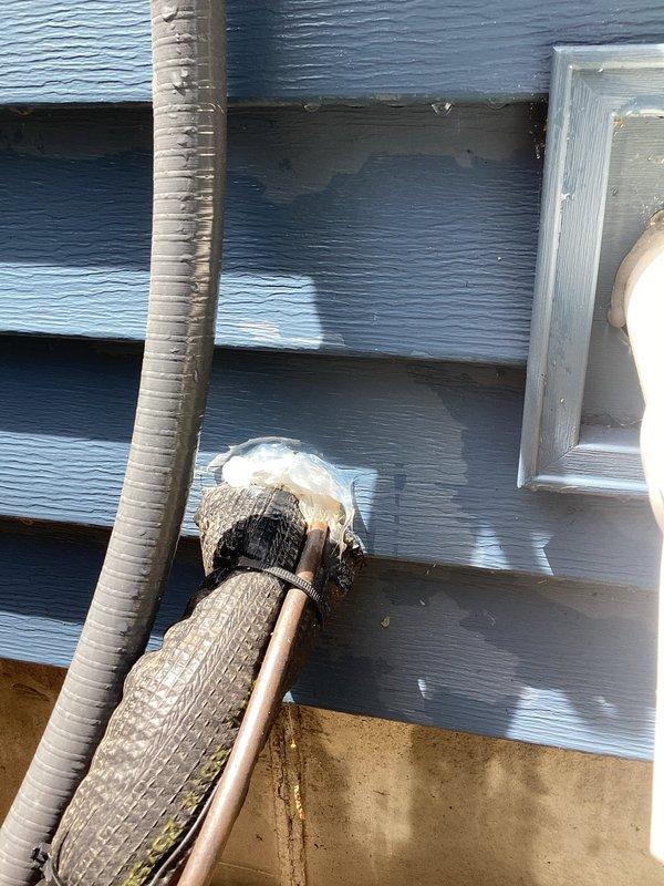 Completed annual AC tune-up on system less than 10 years old. Discovered damaged insulation on exterior refrigerant line with exposed copper and significant frost/ice buildup at wall penetration point, indicating possible refrigerant leak or restriction. Documented conditions with photos for customer review and recommended repair of damaged line insulation and further diagnostic testing to determine cause of abnormal frost formation.