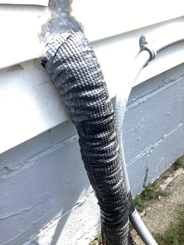 Completed annual heating and cooling maintenance visit including furnace and air conditioning tune-ups. Addressed customer concern regarding furnace running excessively loud during winter operation. Inspected and photographed exterior refrigerant line set, noting severely deteriorated insulation wrapping on copper piping with significant sections torn away and exposing bare copper. Documented condition of condensate drain line showing weathering and surface degradation. System placement verified as acceptable. Performed standard maintenance procedures on both heating and cooling equipment.