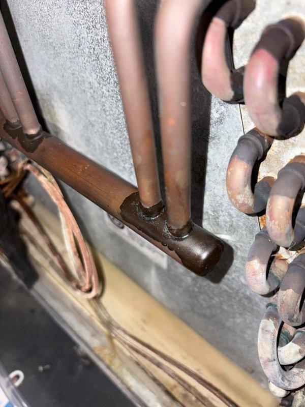 Responded to no cooling condition on 2023 Amana system. Found complete refrigerant loss following previous service visit. Inspected refrigerant circuit and located brazed joint connections on copper lines. Recharged system with refrigerant at no charge to restore cooling operation.