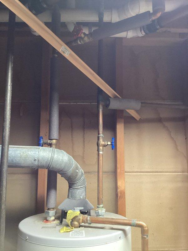 Responded to no hot water call where 14+ year old water heater was found leaking heavily from the bottom tank. Upon arrival, confirmed water supply and pilot light had already been shut off by customer. Inspected unit and documented existing installation showing standard atmospheric gas water heater with copper supply lines, relief valve piping, and metal exhaust venting. Observed water damage on concrete floor and confirmed active leak from tank base, indicating internal tank failure typical of units beyond expected service life. Photographed installation configuration including plumbing connections, shut-off valves, venting arrangement, and overall placement in unfinished basement utility area for replacement planning purposes. Confirmed unit is not located in mobile or manufactured home. Advised that tank replacement is necessary due to catastrophic tank failure and age of existing equipment.