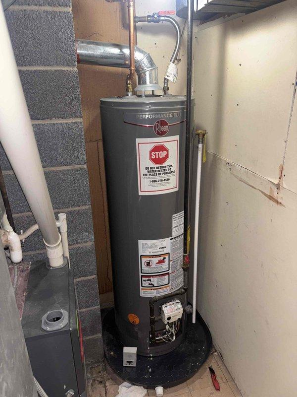 Responded to water heater service call and performed comprehensive inspection of Rheem Performance Plus residential unit located in basement mechanical room. Documented existing installation including copper supply lines, pressure relief valve connections, gas control assembly, and proper drip pan placement. Inspected accessible plumbing connections in crawl space area, including vertical copper piping with brass fittings and galvanized ductwork with support hardware. Verified water heater safety labels present and legible, including manufacturer specifications and warning placards. All components photographed for service records and customer documentation.