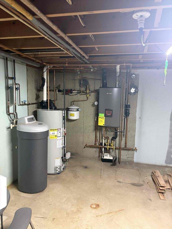 Responded to low water pressure complaint and performed comprehensive diagnostic evaluation of residential hydronic heating system and domestic water supply. Upon inspection, identified and assessed circulator pump operation, pressure reducing valve assembly, zone valves, expansion tank, and system pressure gauge mounted on basement mechanical room wall. Verified proper function of all heating system components including boiler unit, copper distribution piping, isolation valves, and circulation equipment. Documented existing system configuration with photos showing complete installation layout and component arrangement for service records.