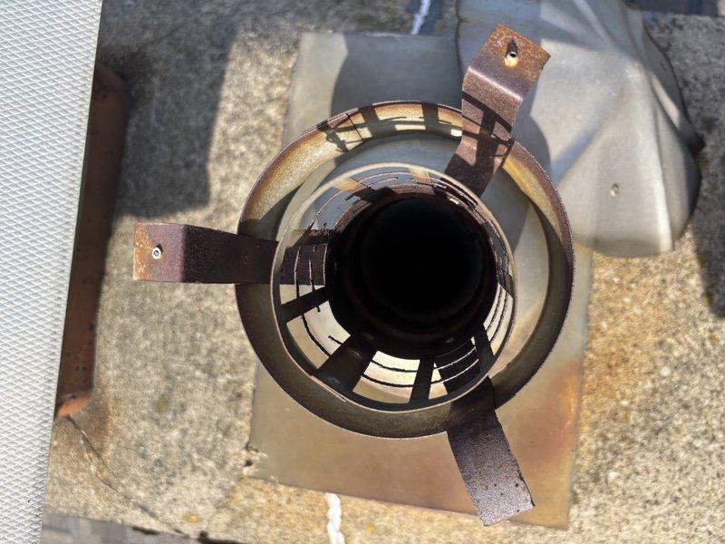 Completed annual cooling maintenance on EnergiAir system with warranty coverage through March 2030. Performed comprehensive tune-up including inspection of rooftop unit components, where significant corrosion and oxidation were observed on mounting brackets and hardware of the flue assembly. Removed and inspected vent cap showing weathering and surface oxidation. All accessible components were evaluated, system operability confirmed, and photographic documentation captured of equipment condition including corroded mounting hardware and oxidized metal surfaces for warranty and maintenance records.