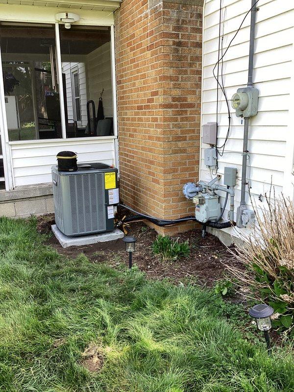Completed full air conditioning system replacement at residential property. Removed existing AC unit and installed new gray condensing unit on concrete pad with proper electrical connections, including meter integration and conduit routing along exterior wall. Connected refrigerant lines with appropriate insulation, installed brass service valves, and performed system testing and commissioning using digital manifold gauges to verify proper refrigerant charge and operating pressures.