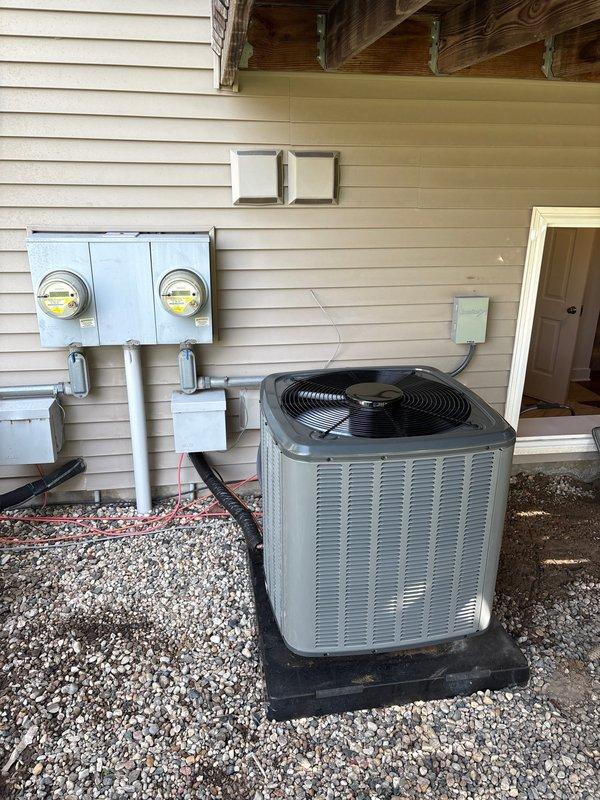 Completed full air conditioning system replacement at residential property. Removed existing AC unit and installed new condenser unit on gravel pad with proper leveling and positioning adjacent to building exterior. Unit mounted on rubber isolation pad for vibration dampening. Connected refrigerant lines to factory-charged system containing 53 oz refrigerant charge with no additional field charge required. Verified all service port connections, installed caps on brass valves, and confirmed proper refrigerant containment. Established electrical connections to existing disconnect box and verified meter compatibility. Tested system startup, confirmed proper operation of condenser fan and compressor, and validated all electrical connections meet code requirements. System operational and performing to manufacturer specifications.