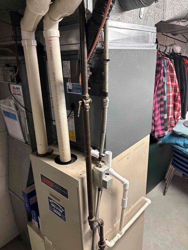 Completed full air conditioning system installation at residential property. Installed new outdoor condenser unit on concrete pad with proper electrical disconnect and refrigerant line connections to indoor air handler. Established refrigerant lines between outdoor unit and existing furnace/air handler assembly in basement utility area, ensuring proper insulation and secure mounting. Verified all electrical connections, tested system operation, and confirmed proper drainage through PVC condensate lines. System commissioned and operating within manufacturer specifications.