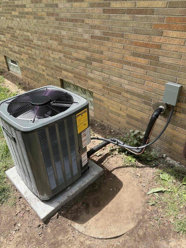 Completed full air conditioning system installation at residential property. Installed new outdoor condenser unit on concrete pad with proper electrical disconnect and refrigerant line connections to indoor air handler. Established refrigerant lines between outdoor unit and existing furnace/air handler assembly in basement utility area, ensuring proper insulation and secure mounting. Verified all electrical connections, tested system operation, and confirmed proper drainage through PVC condensate lines. System commissioned and operating within manufacturer specifications.