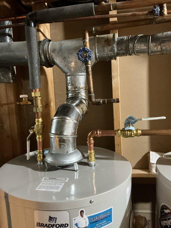 Technician successfully installed a 40-gallon natural gas water heater, tall model, in the mechanical room alongside existing equipment. The installation included proper venting configuration, complete plumbing connections with copper and galvanized piping, shutoff valves, and all necessary fittings per manufacturer specifications and local code requirements.