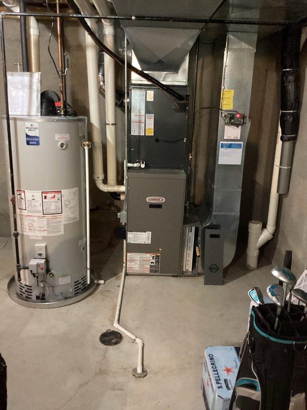 Completed full air conditioning system replacement including outdoor condensing unit and indoor air handler. Installed new Lennox equipment in basement mechanical room alongside existing water heater and furnace. Charged system with proper refrigerant levels per manufacturer specifications, documenting factory charge of 15.5 oz, field charge of 6 oz, for total system charge of 12 lbs. Verified all refrigerant connections, brass fittings, and line sets properly secured and insulated. System tested and operational upon completion.