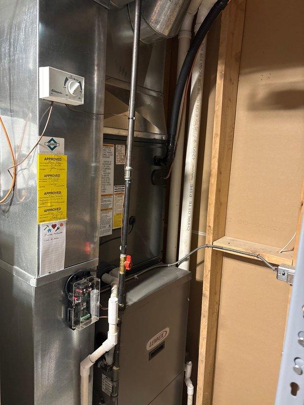 Complete air conditioning system replacement performed at residential property. Removed existing HVAC equipment and installed new Lennox furnace unit in basement utility area with proper venting using white PVC condensate drain lines and ductwork connections including metallic and flexible ducts. Mounted new outdoor condenser unit on concrete pad against exterior wall with proper electrical disconnect box and conduit installation. Verified all manufacturer specifications, completed system startup, and confirmed proper operation of both indoor and outdoor components.
