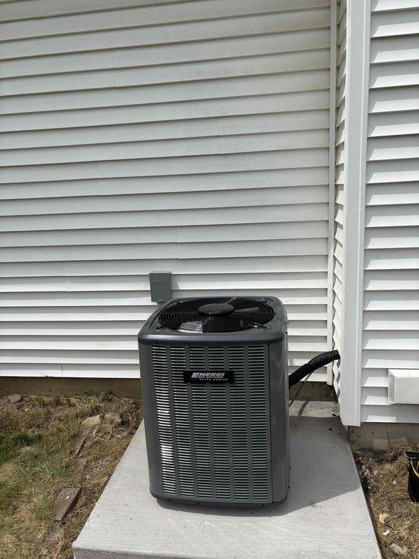 Completed full HVAC system installation including new furnace and air conditioning unit. Installed dark-colored condensing unit on concrete pad against exterior wall with proper clearances and mounted new gas furnace in basement mechanical room with complete PVC venting system, condensate drainage lines, and proper ductwork connections. All equipment positioned per manufacturer specifications, system tested and operational, with financing documentation processed through Michigan Saves program.