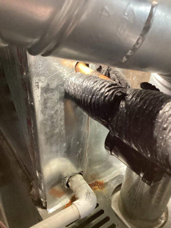 # AC Tune-Up Completed

Performed comprehensive AC tune-up service on 2-year-old Payne system. Inspection revealed significant deterioration of flexible return air duct with tears and damaged insulation layer exposing inner material, which could compromise system efficiency and indoor air quality. Documented damaged ductwork and drainage components showing moisture exposure, staining, and age-related wear on metal surfaces within air handler cabinet.
