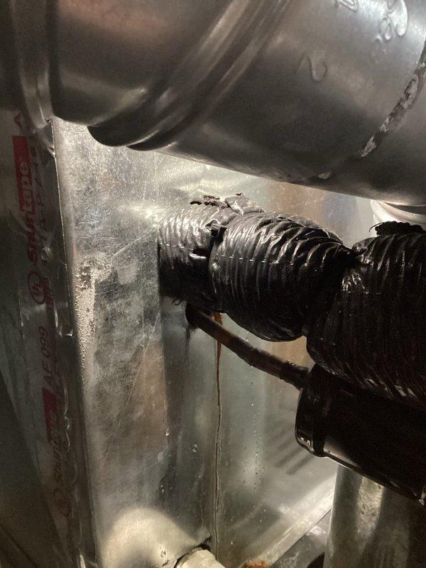 # AC Tune-Up Completed

Performed comprehensive AC tune-up service on 2-year-old Payne system. Inspection revealed significant deterioration of flexible return air duct with tears and damaged insulation layer exposing inner material, which could compromise system efficiency and indoor air quality. Documented damaged ductwork and drainage components showing moisture exposure, staining, and age-related wear on metal surfaces within air handler cabinet.
