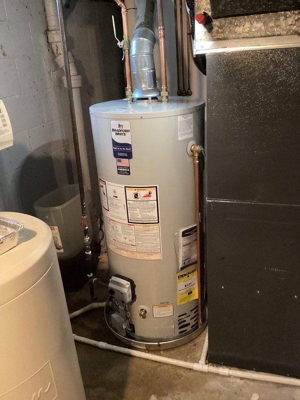 Installed a 40-gallon natural draft, natural gas Bradford White water heater (short tank model, 48 1/16" height) in basement utility area. Connected copper supply and discharge piping to unit, installed pressure relief valve with proper discharge piping, and integrated existing expansion tank into the system. Unit is covered by 6-year parts and 1-year labor warranty and is fully operational.