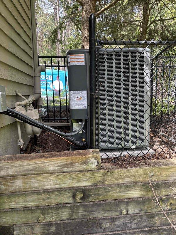 Completed full HVAC system installation including new furnace and air conditioning unit. Interior furnace installed in mechanical room with proper PVC venting configuration routed through multiple joints to exterior, all manufacturer labels and warning plates intact and visible. Exterior condensing unit positioned against house with refrigerant lines and electrical conduit properly secured to vinyl siding, unit grounded and leveled on prepared pad near property fence line with drainage provisions in place.