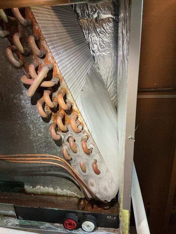 Responded to no cooling complaint on 7-year-old Luxaire system. Upon inspection, discovered evaporator coil assembly with extensive rust and corrosion throughout copper tubing and fins, indicating severe deterioration beyond serviceable condition. Documented system condition with photos showing compromised heat exchanger coil, corroded refrigerant lines, and overall equipment degradation requiring coil replacement or full system evaluation.