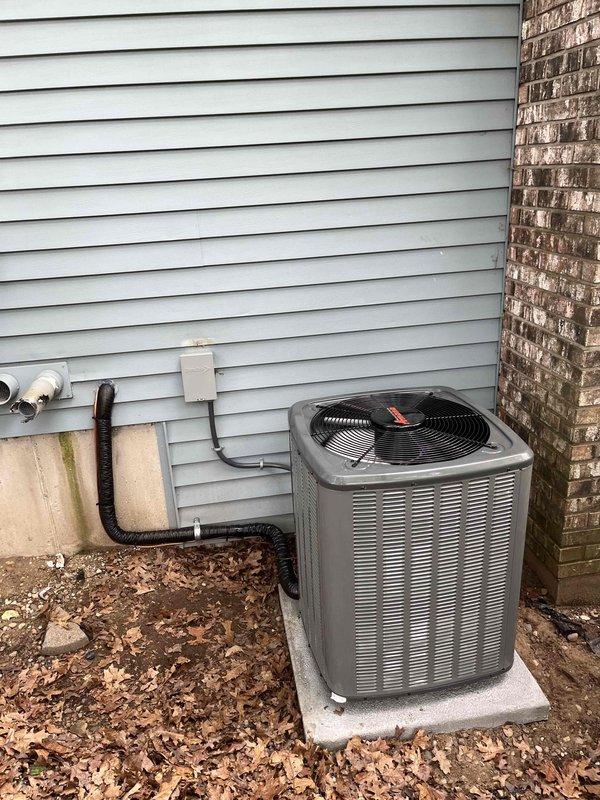 Completed full air conditioning system replacement. Removed existing outdoor condensing unit and installed new HVAC condenser on concrete pad against exterior wall. Ran refrigerant lines from new unit through exterior penetration into home, securing copper lines and insulated tubing to siding. Connected service valves and brass fittings to refrigerant lines at condensing unit. Verified all connections, sealed wall penetrations, and completed system startup with proper refrigerant charge levels documented on service labels.