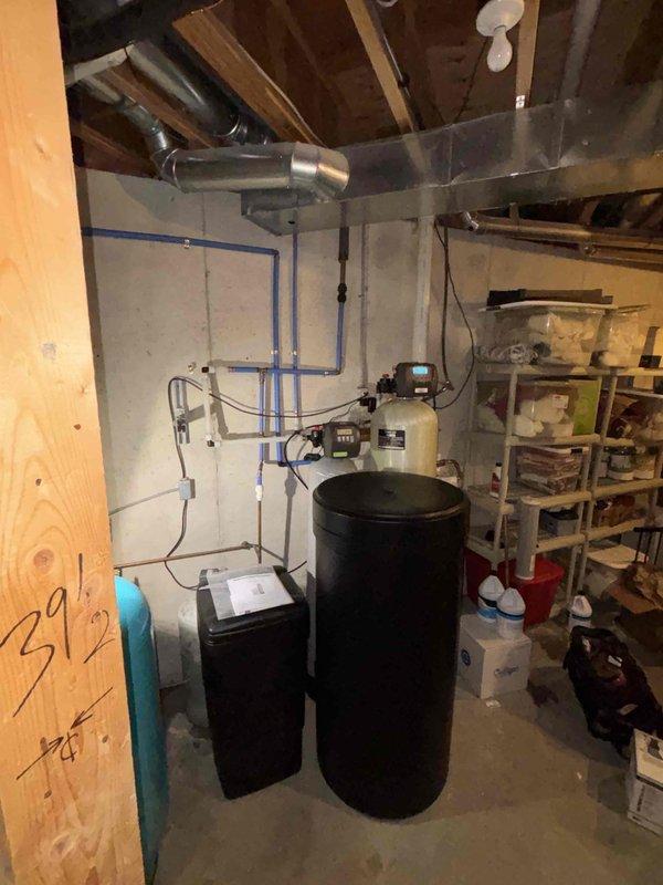 Completed comprehensive water conditioning system replacement in basement utility area. Removed and disposed of existing water treatment equipment, then installed Sterling PS1X-75 water softener and iron reduction system, 4x20 carbon filter, and Sterling SWSI-45 HE water softener with complete PEX piping connections and mounting. Additionally replaced recirculating pump on water heating system in well room to restore proper hot water circulation throughout the property.