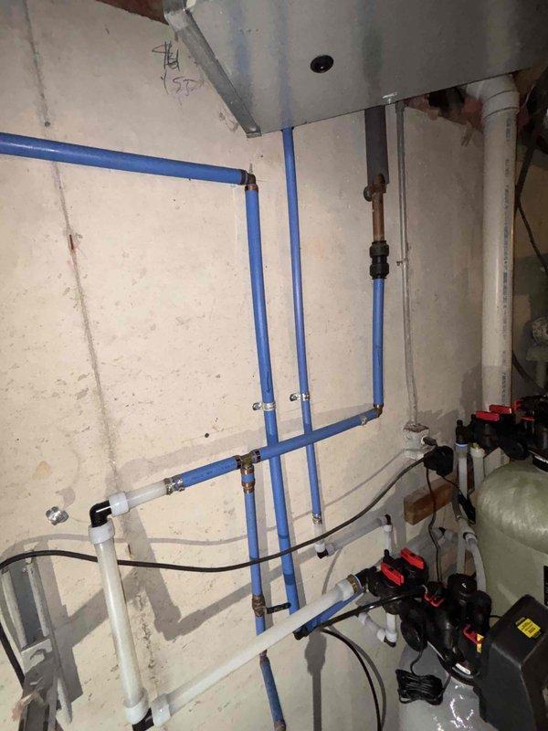 Completed comprehensive water conditioning system replacement in basement utility area. Removed and disposed of existing water treatment equipment, then installed Sterling PS1X-75 water softener and iron reduction system, 4x20 carbon filter, and Sterling SWSI-45 HE water softener with complete PEX piping connections and mounting. Additionally replaced recirculating pump on water heating system in well room to restore proper hot water circulation throughout the property.