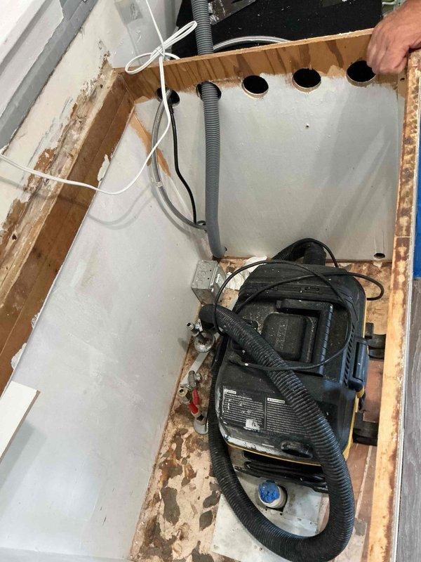 Completed comprehensive plumbing project estimate for residential property including assessment of kitchen and bathroom plumbing needs. Evaluated requirements for dishwasher installation, kitchen sink replumbing, and bathroom sink connection replacement. Documented existing conditions including access points through floor structure with visible framing and plumbing infrastructure, as well as bathroom area showing water damage indicators on wooden framing and surrounding surfaces requiring attention during planned plumbing work.