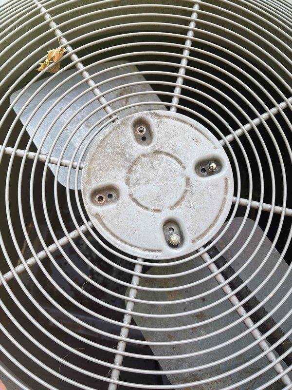 Responded to no cool complaint on 19-year-old Carrier residential AC system. Upon arrival, unit was operational but not cooling adequately. Performed visual inspection of outdoor condenser unit, documenting fan assembly and guard condition. Fan guard and blades showed normal wear and debris accumulation consistent with outdoor exposure. Captured diagnostic photos of condenser fan assembly showing intact protective guard with concentric wire rings, central hub mounting plate, and operational fan blades. Unit components appeared structurally sound with typical dust and environmental buildup. Recommended follow-up service for complete system diagnostics to identify cooling efficiency issue.