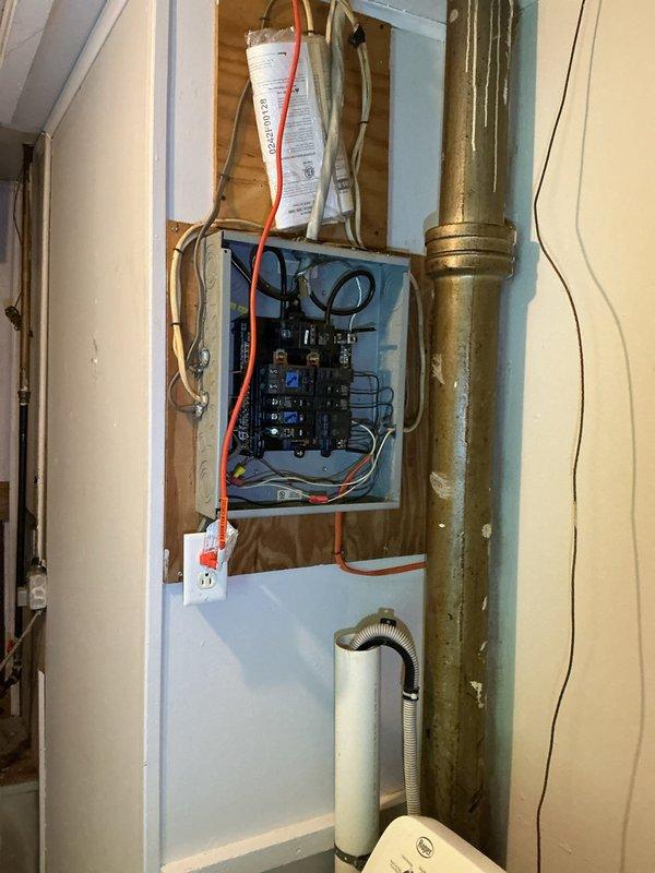 Responded to inquiry regarding bathroom exhaust fan wiring and installation. Conducted site assessment and documented existing electrical panel configuration in utility area. Panel inspection revealed multiple circuit breakers with various wire gauges including orange and red cables, adjacent to vertical metallic ductwork and ventilation components in unfinished utility space. Advised client that exhaust fan installation and wiring falls outside current service scope and recommended referral to qualified electrician for proper evaluation and installation work.
