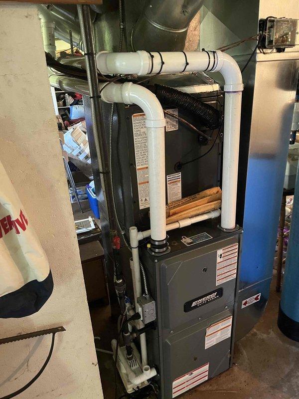 Completed full ACREP-AC system replacement including indoor and outdoor components. Installed new Amana condensing unit on existing concrete pad with proper electrical disconnect and refrigerant line connections. Mounted new furnace/air handler in basement mechanical room with appropriate venting using white PVC piping secured with proper fasteners. Ran electrical conduit and established all necessary connections between indoor and outdoor units. Verified proper refrigerant charge, tested system operation through complete cooling cycle, and confirmed all safety controls functioning correctly. System commissioned and left operational.