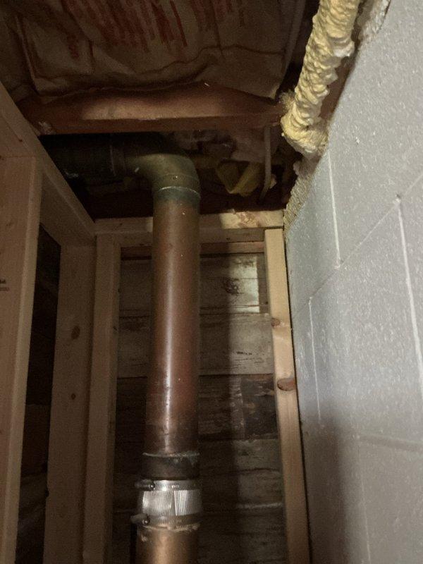 Responded to service call for non-operational sump pump and outdoor faucet replacement. Upon inspection, assessed the sump pump discharge piping system running through the ceiling cavity and attic space. Documented existing metal discharge pipe configuration and routing through wooden framing members, noting aged galvanized ductwork and surrounding building infrastructure. Identified issues with the sump pump system and provided recommendations for repair to restore proper functionality and prevent potential water damage.