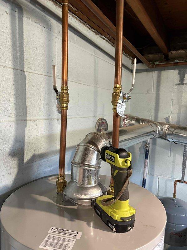Completed installation of a 40-gallon natural gas water heater in basement utility room. Connected all copper supply lines with brass fittings to existing plumbing system, integrated white PEX piping, and verified proper connections to building's hot water distribution network. Unit is fully operational with 6-year parts and labor warranty coverage.