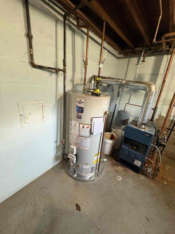 Completed installation of a 40-gallon natural gas water heater in basement utility room. Connected all copper supply lines with brass fittings to existing plumbing system, integrated white PEX piping, and verified proper connections to building's hot water distribution network. Unit is fully operational with 6-year parts and labor warranty coverage.
