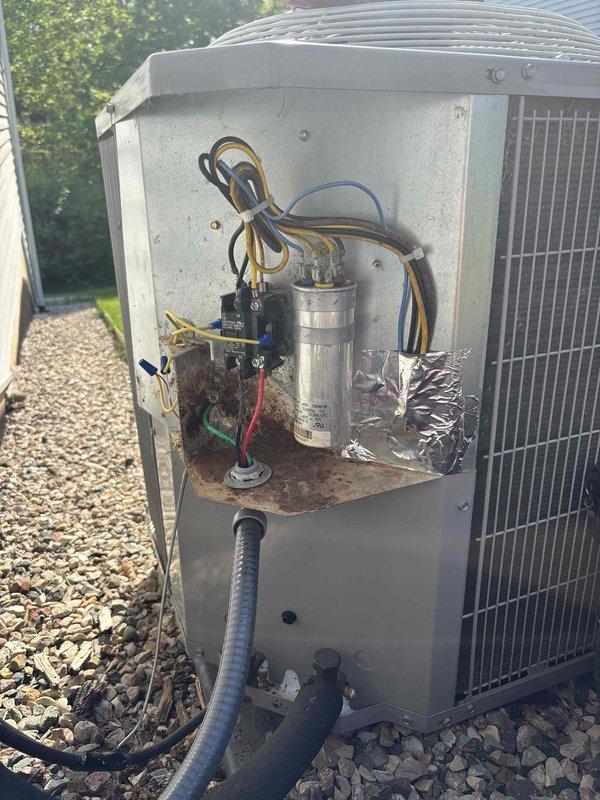 # CP-Cooling Problem Service Completed

Responded to service call for 7-year-old Carrier air conditioning system not cooling house sufficiently, though blower was operational. Upon arrival, performed visual inspection of outdoor condensing unit and electrical components.

Opened electrical panel on outdoor unit and discovered significant rust and corrosion on contactor/relay switch, particularly concentrated on its surface, mounting area, and base. Corrosion was also present on base plate inside panel compartment, especially around mounting points and lower edges. This level of deterioration on critical electrical components was preventing proper system operation and contributing to cooling failure.

Inspected capacitor, wiring connections, and electrical terminals. Examined heat exchanger fins which appeared in relatively clean condition. Verified electrical disconnect box and conduit connections at building exterior. Documented equipment condition with photographs showing extent of c