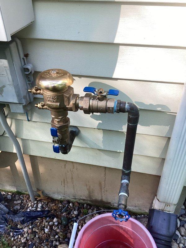 Responded to exterior plumbing leak at outdoor hose bib assembly with backflow preventer. Upon arrival, found active leak at brass fitting connection that had been temporarily left incomplete during previous fall repair when outdoor pipe burst. The irrigation system had since been reconnected for spring season, allowing for completion of the original repair. Inspected backflow preventer assembly with multiple shut-off valves and confirmed leak isolated to brass threaded connection point. Properly secured and tightened brass fittings with appropriate gasket seal to complete the connection that had been deferred pending irrigation system reactivation. Verified all connections sealed, tested system under pressure, and confirmed no further leakage at exterior water service point.