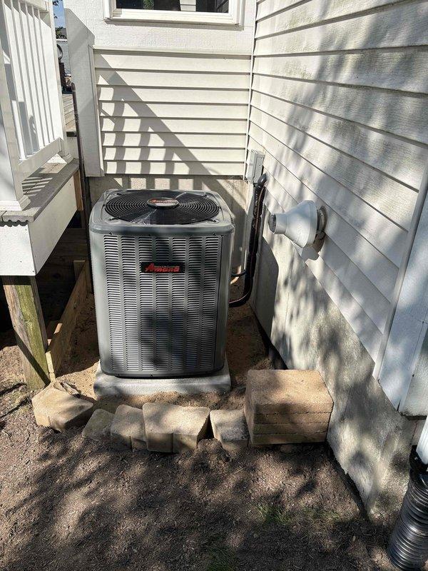 Completed full HVAC system installation including outdoor Amana condensing unit positioned in side yard on concrete paver pad with proper clearances and indoor furnace with air handler in basement mechanical room. Ran refrigerant line set from exterior unit through wall penetration with secure mounting brackets and proper insulation. Installed white PVC condensate drain piping and venting system connected to furnace, routed along basement ceiling to code-compliant termination points. Positioned equipment on protective pads over concrete surfaces. Connected all electrical components, verified proper voltage and amperage to both indoor and outdoor units. Pressure tested refrigerant lines for leaks, evacuated system, and charged to manufacturer specifications. Verified airflow, temperature split, and proper cycling of both heating and cooling modes. All installations meet current building codes and manufacturer requirements for warranty compliance.
