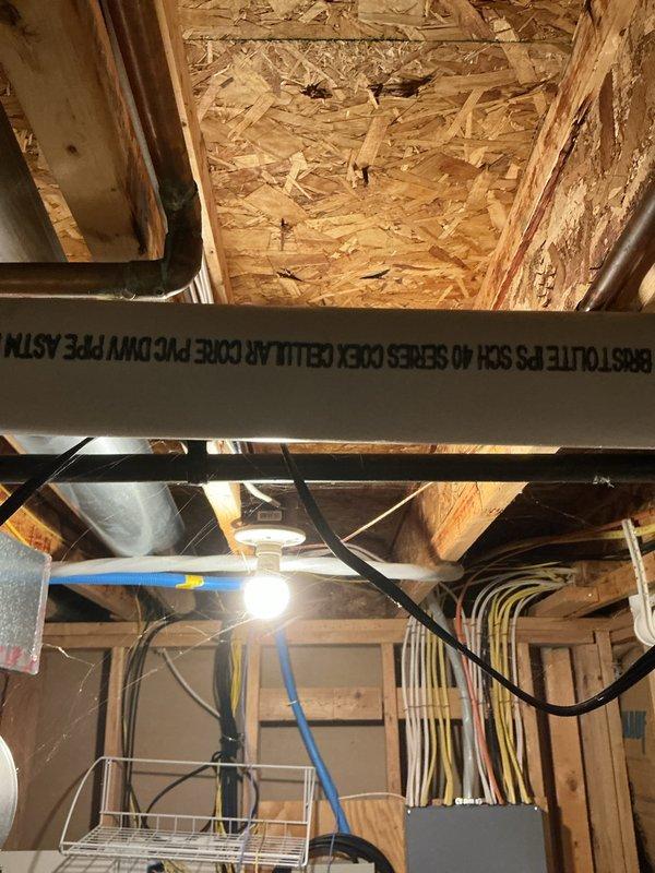 Responded to service call for inadequate cooling on upper floor of three-story residence with approximately 8-year-old HVAC system. Performed diagnostic evaluation of air conditioning unit and inspected accessible ductwork and mechanical systems in basement utility area. Documented equipment conditions and system components including water heater, pressure tank, electrical conduits, and PEX plumbing lines during inspection. Unable to identify definitive cause of cooling deficiency from visual inspection of accessible areas; recommended further diagnostic testing of refrigerant levels, airflow measurements, and zoning system functionality to isolate root cause of insufficient cooling performance on upper level.