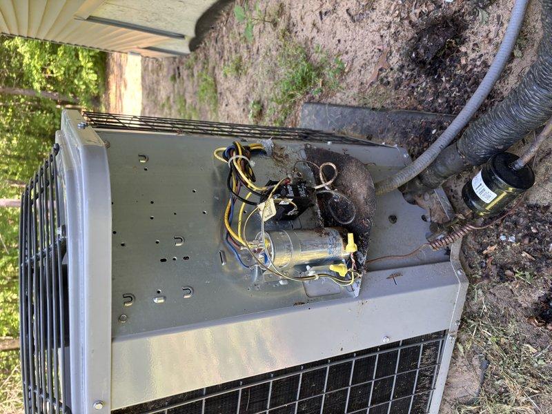 Responded to service call for outdoor air conditioning unit experiencing operational issues. Upon arrival, accessed the outdoor condensing unit by opening the top panel to inspect internal electrical and mechanical components. Found significant corrosion and rust accumulation on the unit housing and internal surfaces, indicating prolonged exposure to moisture and environmental elements. Inspected the capacitor and associated electrical wiring, including yellow and black striped conductors. Examined copper refrigerant lines and electrical connections for signs of deterioration. Documented the condition of the unit through photographs showing weathered components, corroded metal surfaces, and wire connections. The unit displayed evidence of age-related wear with dirt accumulation on internal components and surrounding areas. All findings were recorded for maintenance recommendations and future service planning.