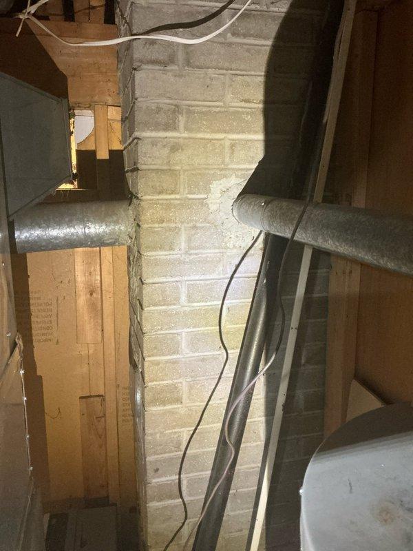 Conducted comprehensive estimate for HVAC system upgrades at owner-occupied residence. Evaluated existing 20-year-old furnace and 24-year-old water heater for replacement, assessed installation requirements for new air conditioning system where none currently exists. Inspected basement utility area including existing ductwork configuration, structural elements, and available space for new equipment installation. Photographed current furnace unit with connected metal ductwork and flexible ducting, documented exposed framing and insulation conditions in mechanical room. Prepared separate estimate options: one for AC addition only, and another for complete system replacement including furnace, air conditioner, and water heater.