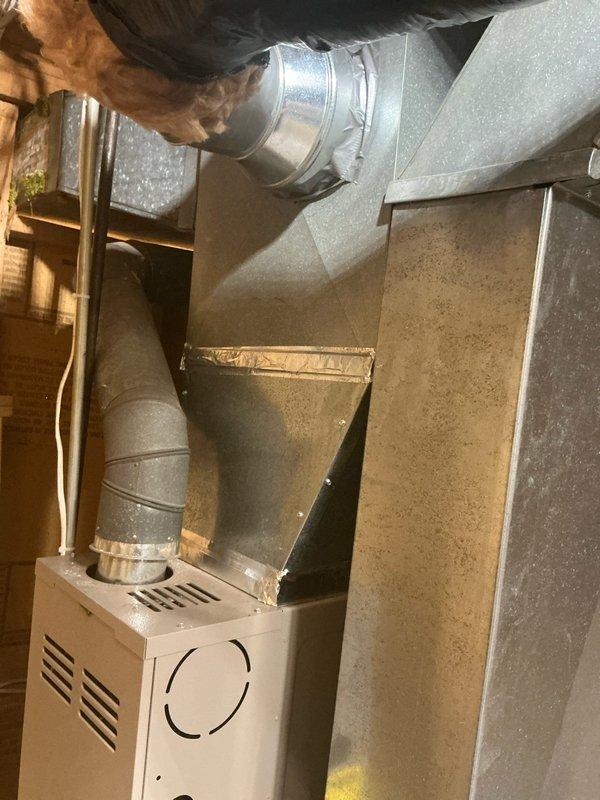 Conducted comprehensive estimate for HVAC system upgrades at owner-occupied residence. Evaluated existing 20-year-old furnace and 24-year-old water heater for replacement, assessed installation requirements for new air conditioning system where none currently exists. Inspected basement utility area including existing ductwork configuration, structural elements, and available space for new equipment installation. Photographed current furnace unit with connected metal ductwork and flexible ducting, documented exposed framing and insulation conditions in mechanical room. Prepared separate estimate options: one for AC addition only, and another for complete system replacement including furnace, air conditioner, and water heater.