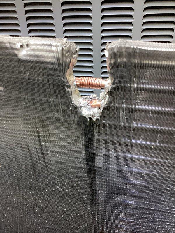 Returned to site to complete quoted condenser coil repair. Upon inspection, confirmed extensive corrosion damage to the condenser coil with compromised refrigerant tubing and deteriorated fin sections. The unit exhibited severe oxidation with a large corroded cavity penetrating through multiple layers of the coil assembly, along with torn copper refrigerant lines showing exposed metal and damaged insulation material.

Performed complete condenser coil replacement to restore system functionality. Removed damaged coil assembly and installed new condenser coil unit. Reconnected refrigerant lines with proper brazing techniques and installed new line insulation. Verified all connections for integrity and proper fitment. System restored to operational condition.