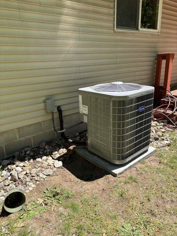 Completed full system replacement including new furnace and air conditioning condenser unit. Installed Carrier outdoor condensing unit on white pad against exterior wall with proper electrical disconnect and conduit routing. Connected all ductwork, refrigerant lines, and drainage components, ensuring proper system operation and code compliance.