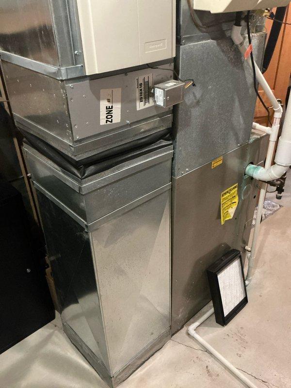 Responded to service call for non-operational furnace and air conditioning system. Upon arrival, inspected existing Bryant brand forced-air heating system and associated HVAC equipment located in basement mechanical room. Evaluated current furnace unit showing typical wear and dust accumulation consistent with operational age. Assessed air handling components, ductwork connections, and electrical control systems mounted on upper portion of equipment. Examined PVC condensate drainage piping, copper refrigerant lines with shutoff valves, and galvanized metal ductwork distribution system. Documented equipment configuration including zone control components and filter access panels. Reviewed water heater proximity and clearance requirements for replacement considerations. Provided comprehensive estimate for complete furnace and air conditioning system replacement based on equipment condition assessment and customer heating and cooling needs.