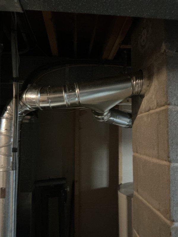 Completed installation of a 40-gallon Bradford White natural gas water heater with 6-year warranty in residential basement utility area. Unit installed as short model with proper venting, copper supply line connections with brass fittings, and black iron gas piping, positioned on concrete floor against exposed wall framing per manufacturer specifications and local building codes.