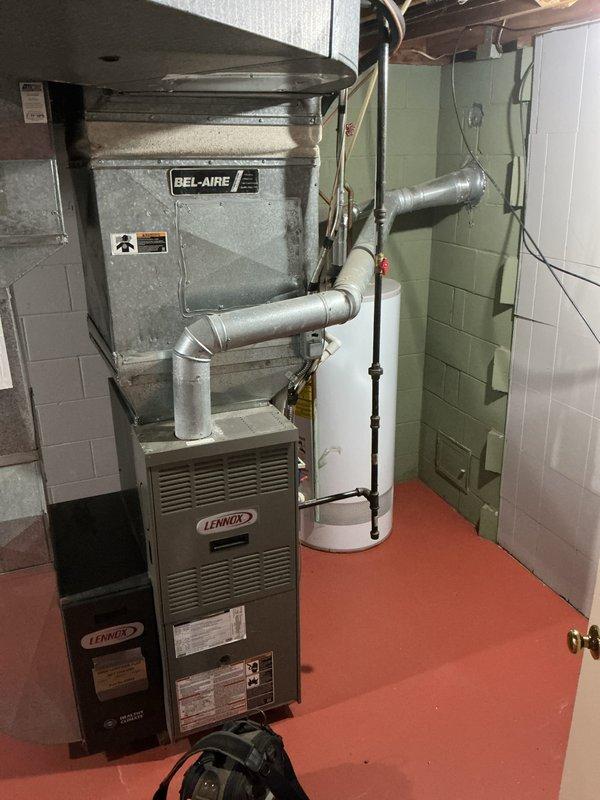 Completed water heater estimate for 40-gallon natural gas unit replacement in basement mechanical room. Assessed existing installation, documented current equipment configuration including proximity to Lennox furnace system and existing gas line with shutoff valve, and photographed workspace conditions to provide accurate replacement proposal.
