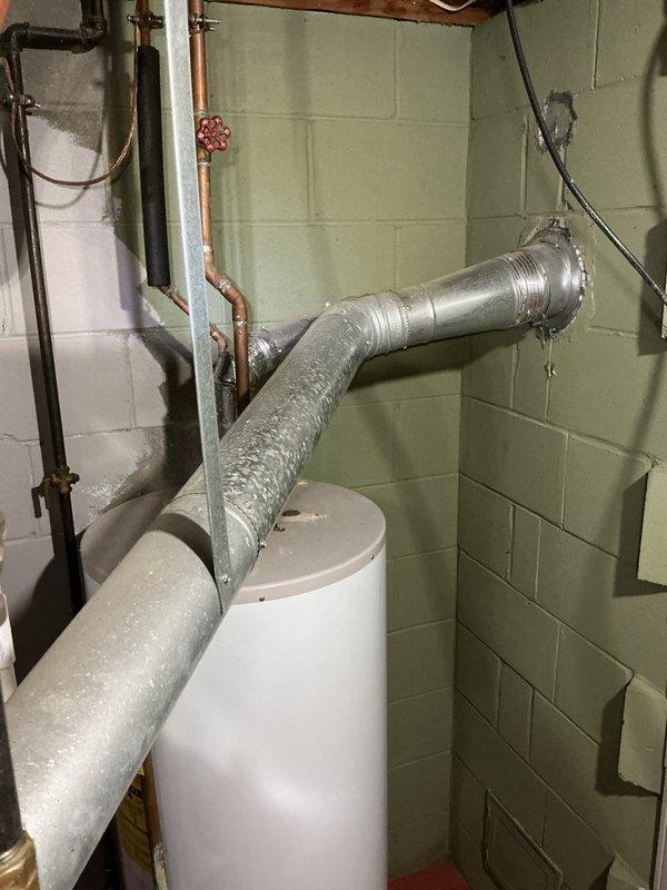 Completed water heater estimate for 40-gallon natural gas unit replacement in basement mechanical room. Assessed existing installation, documented current equipment configuration including proximity to Lennox furnace system and existing gas line with shutoff valve, and photographed workspace conditions to provide accurate replacement proposal.